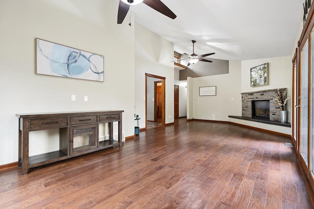 unfurnished living room featuring dark wood-style floors, a fireplace, baseboards, and a ceiling fan