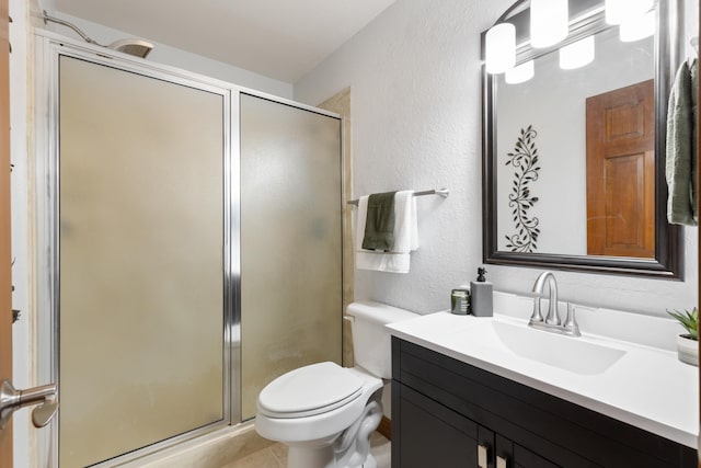 full bathroom with toilet, a textured wall, a shower stall, and vanity