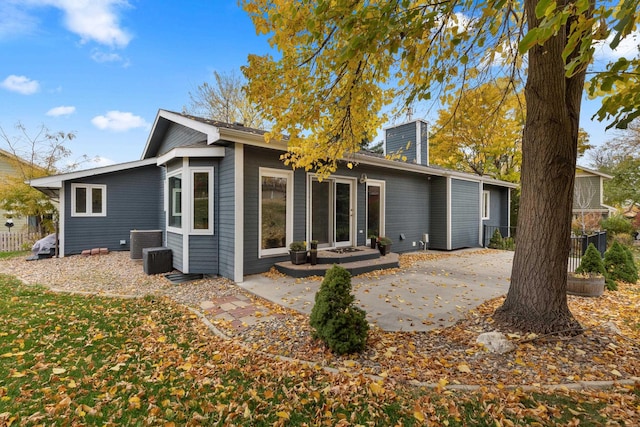 rear view of house featuring central AC, a patio, a chimney, and fence