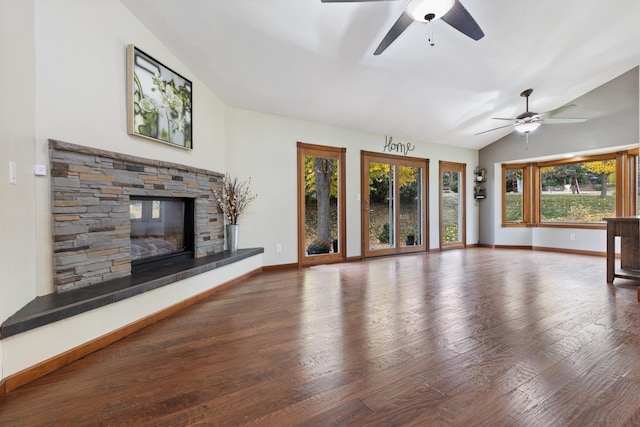 unfurnished living room with lofted ceiling, a fireplace, wood finished floors, a ceiling fan, and baseboards