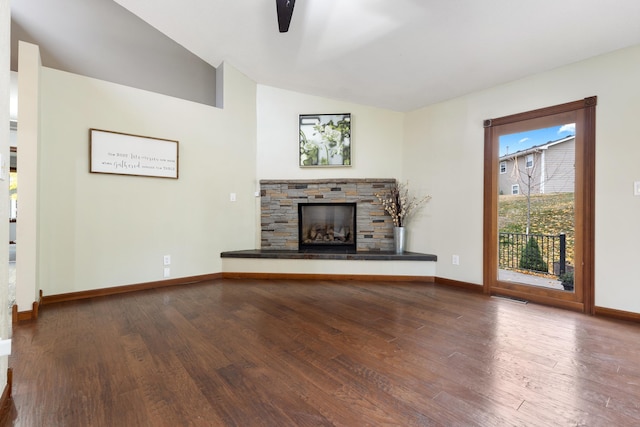 unfurnished living room with vaulted ceiling, a fireplace, wood finished floors, and baseboards