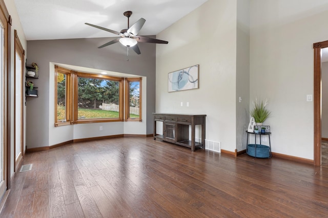 unfurnished living room featuring lofted ceiling, dark wood-style flooring, visible vents, and baseboards