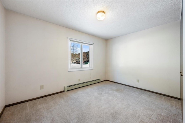 carpeted empty room featuring a baseboard heating unit, a textured ceiling, and baseboards