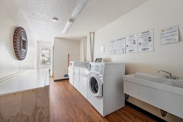 community laundry room featuring a textured ceiling, wood finished floors, independent washer and dryer, and a sink