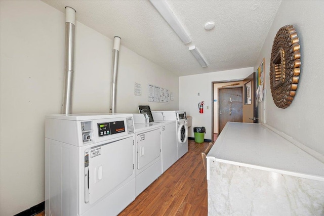 shared laundry area with a textured ceiling, washer and clothes dryer, wood finished floors, and baseboards