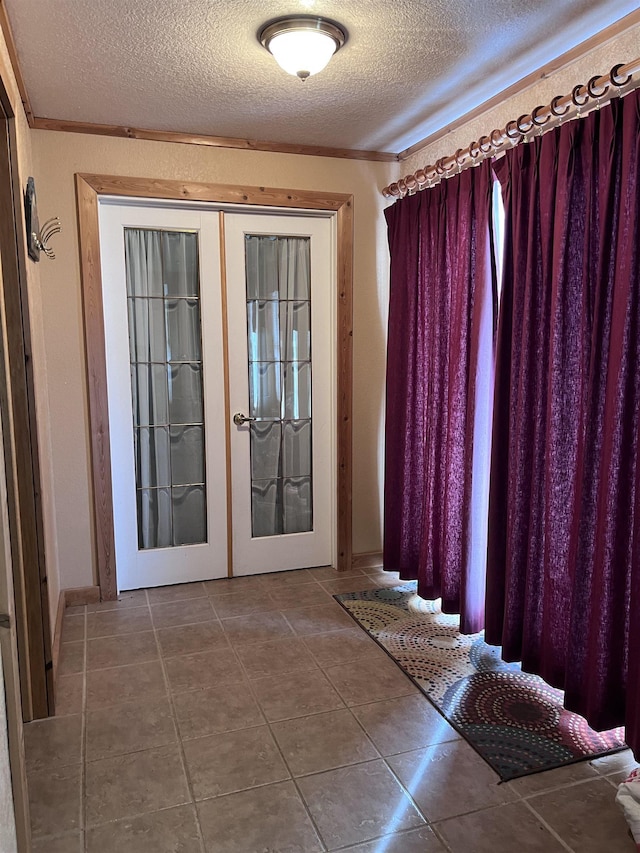 entryway featuring french doors, a textured ceiling, and tile patterned floors