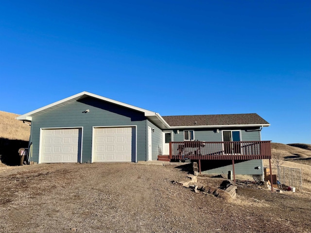 ranch-style home with driveway and a wooden deck