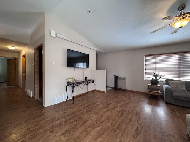 living room featuring dark wood-style floors, visible vents, vaulted ceiling, and a ceiling fan