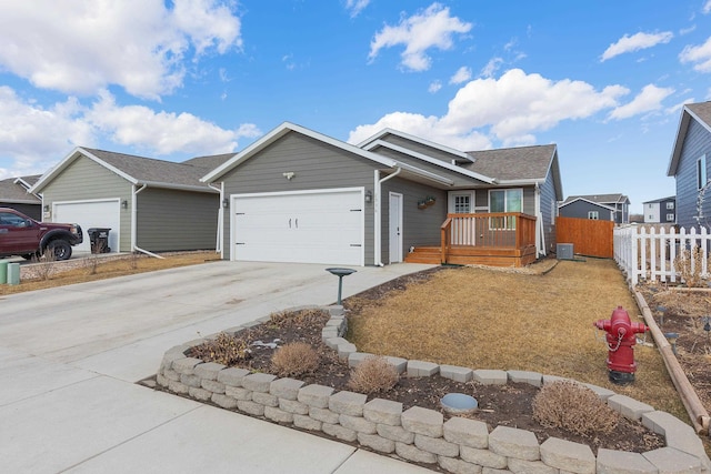 ranch-style home with concrete driveway, an attached garage, and fence