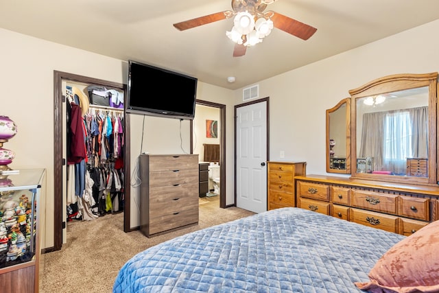 bedroom with light carpet, visible vents, a ceiling fan, a spacious closet, and a closet