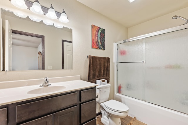 bathroom featuring toilet, shower / bath combination with glass door, and vanity