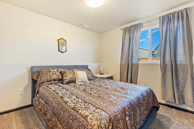 bedroom with carpet floors, visible vents, and baseboards