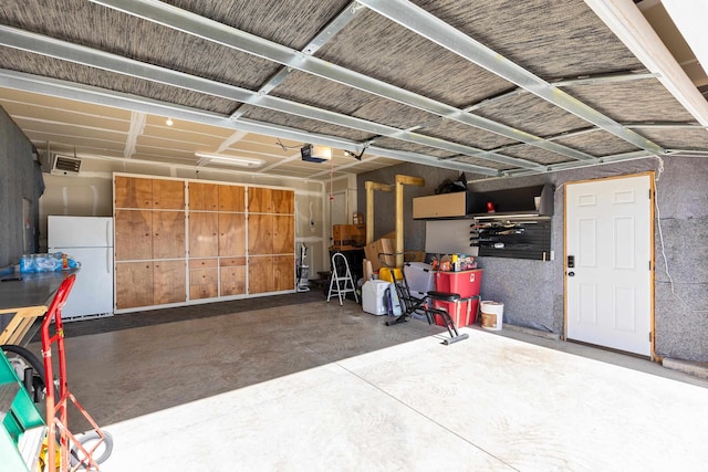 garage with freestanding refrigerator and a garage door opener