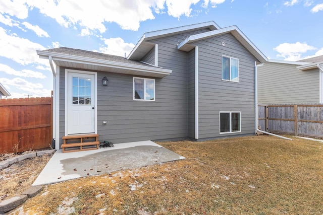 rear view of property with entry steps, a patio area, and a fenced backyard