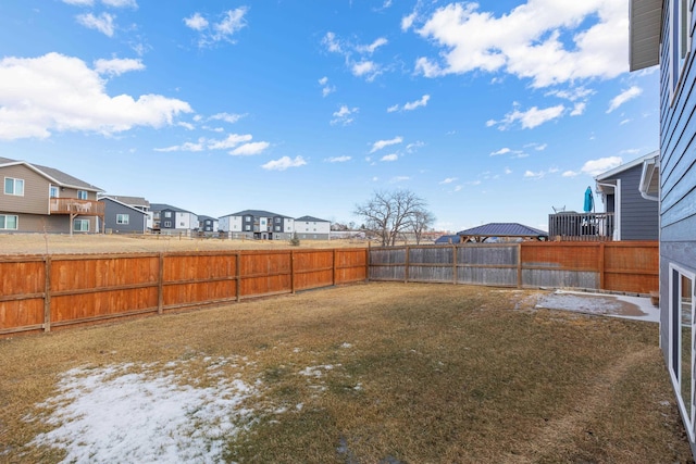 view of yard featuring a fenced backyard and a residential view