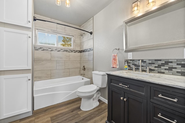 bathroom featuring tasteful backsplash, toilet, washtub / shower combination, vanity, and wood finished floors