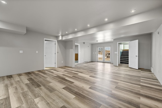 unfurnished living room featuring light wood-type flooring, visible vents, recessed lighting, and stairs