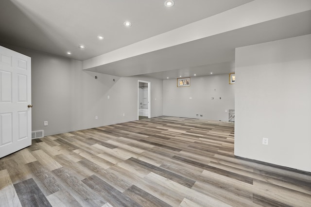 finished basement featuring light wood-style floors, recessed lighting, and visible vents