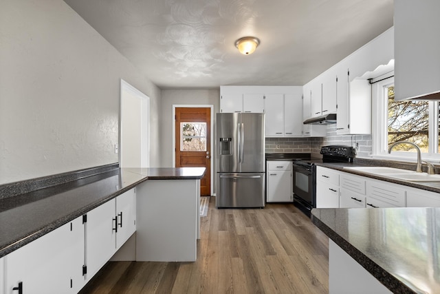 kitchen with stainless steel fridge with ice dispenser, dark countertops, black / electric stove, under cabinet range hood, and white cabinetry