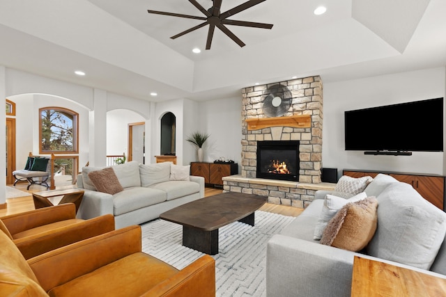 living room featuring a fireplace, a tray ceiling, and recessed lighting