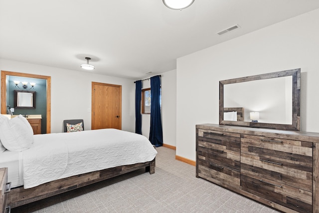 bedroom featuring visible vents, connected bathroom, light carpet, and baseboards