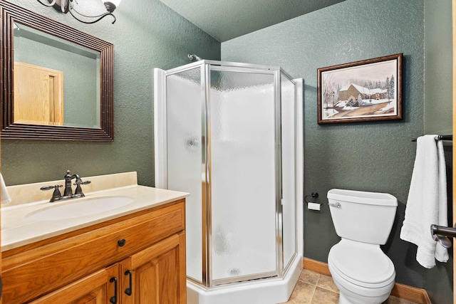 full bath featuring a stall shower, a textured wall, toilet, tile patterned floors, and vanity