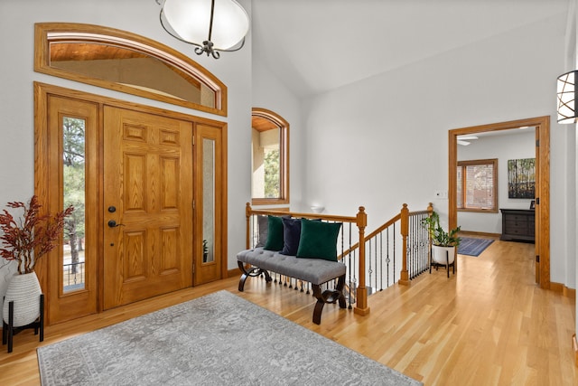 entryway featuring lofted ceiling, light wood finished floors, a wealth of natural light, and baseboards