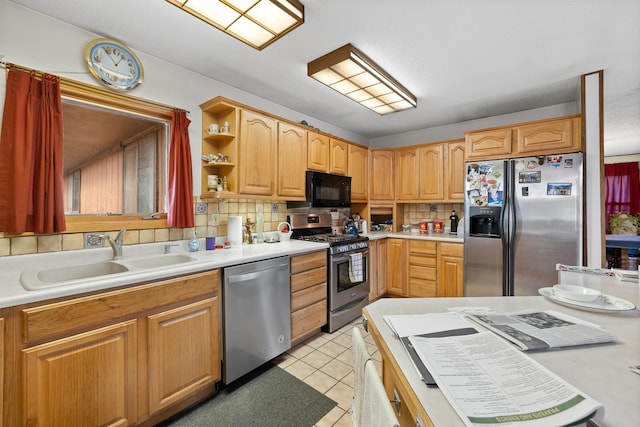 kitchen with appliances with stainless steel finishes, light tile patterned flooring, a sink, and tasteful backsplash