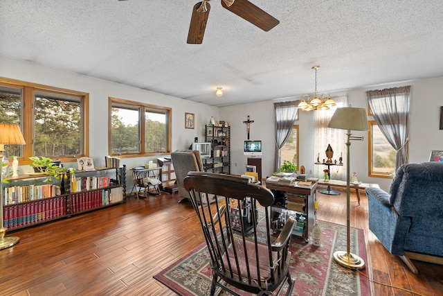 interior space with a textured ceiling, ceiling fan with notable chandelier, and wood finished floors