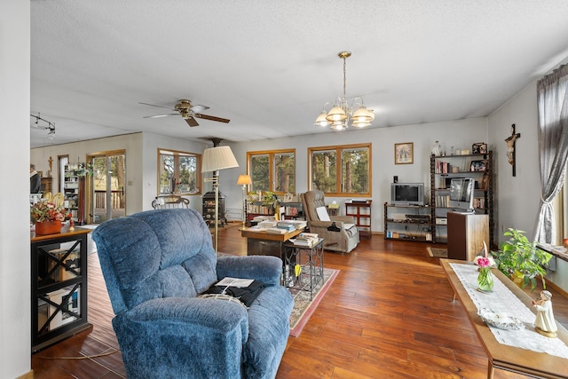 living room with a textured ceiling, ceiling fan with notable chandelier, wood finished floors, and track lighting