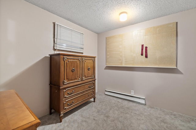 bedroom with a baseboard heating unit, a textured ceiling, and light carpet