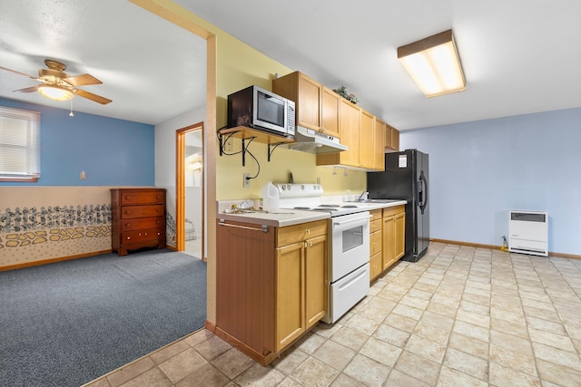 kitchen featuring white electric stove, heating unit, light countertops, stainless steel microwave, and under cabinet range hood