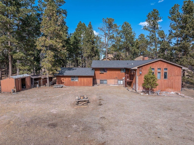 rear view of house with a chimney and an outdoor structure