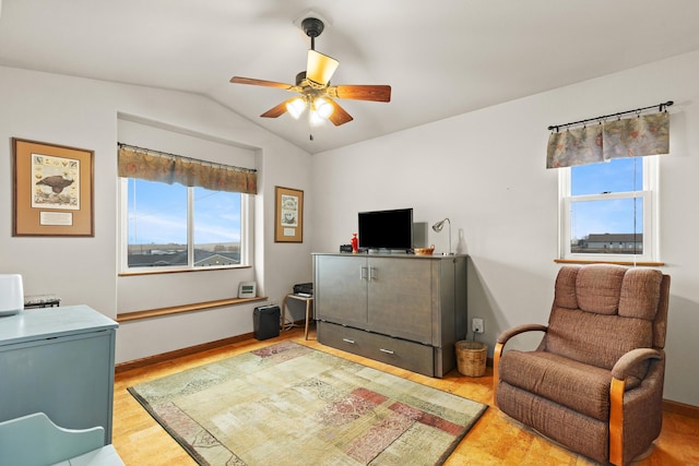 interior space featuring lofted ceiling, light wood finished floors, ceiling fan, and baseboards