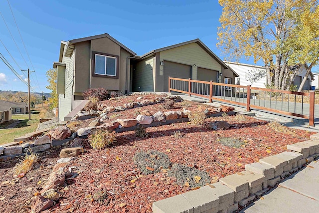 ranch-style home with a garage, fence, and stucco siding