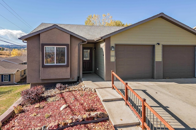 ranch-style house with a garage, concrete driveway, a shingled roof, and stucco siding