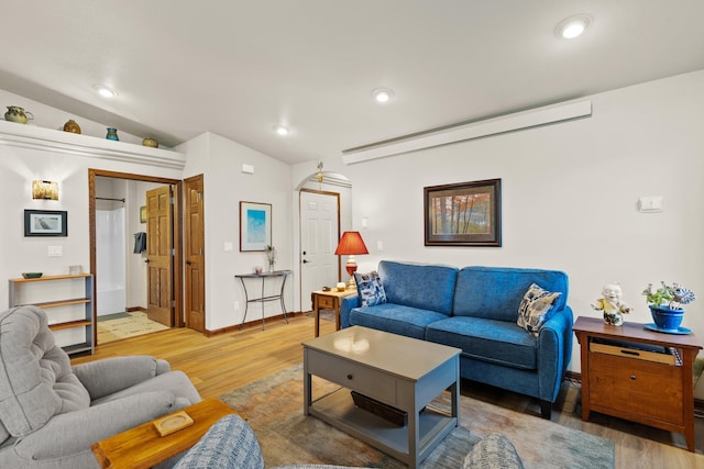 living room with lofted ceiling, light wood-type flooring, and recessed lighting