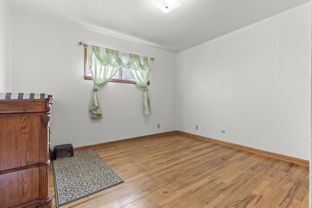 empty room featuring hardwood / wood-style floors and baseboards