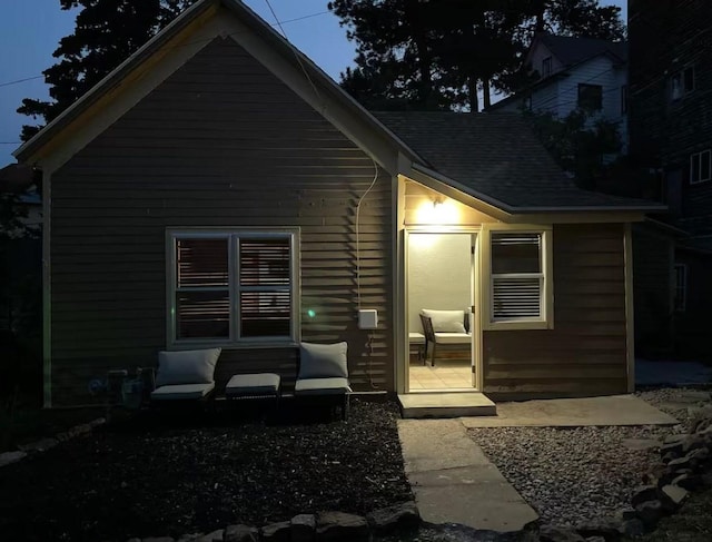 rear view of property with roof with shingles