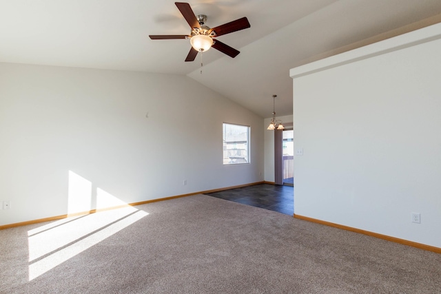 empty room with ceiling fan with notable chandelier, baseboards, vaulted ceiling, and dark colored carpet