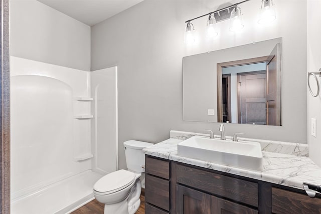 full bathroom with toilet, a shower, wood finished floors, and vanity