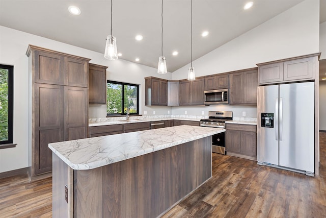 kitchen featuring dark brown cabinetry, a sink, appliances with stainless steel finishes, a center island, and dark wood-style floors