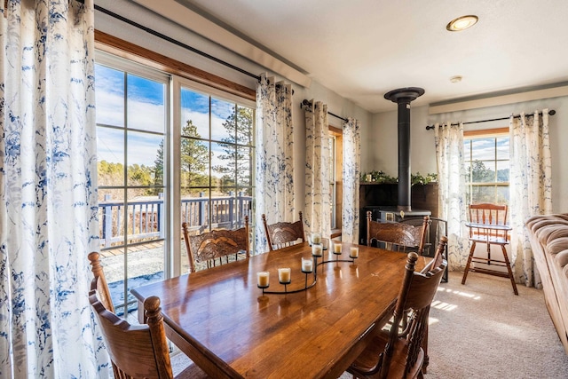 dining space featuring a wood stove and carpet flooring