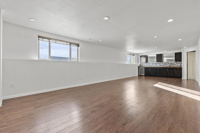 3316 Other, Rapid City, SD 57701 - unfurnished living room with dark wood-style floors, a textured ceiling, baseboards, and recessed lighting