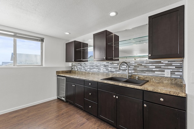 3316 Other, Rapid City, SD 57701 - kitchen with a sink, baseboards, dark brown cabinets, decorative backsplash, and dark wood-style floors
