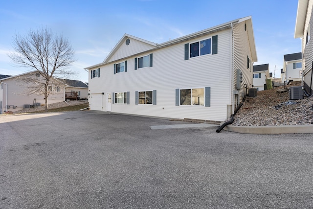 view of front of home featuring an attached garage and cooling unit