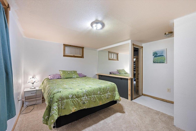 carpeted bedroom featuring a textured ceiling and baseboards