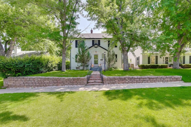 view of front of property with a chimney and a front lawn