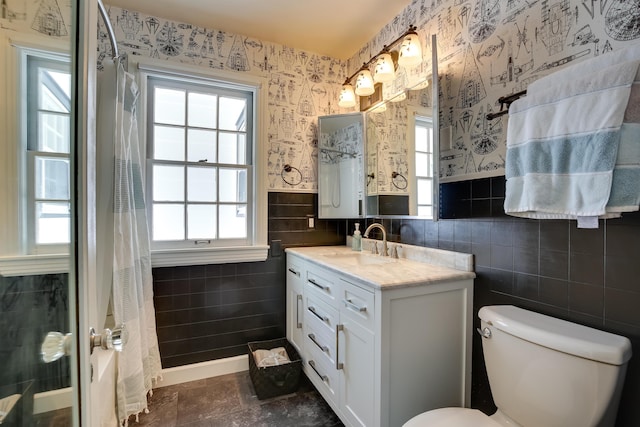 bathroom featuring a wealth of natural light, a shower with shower curtain, toilet, and wallpapered walls