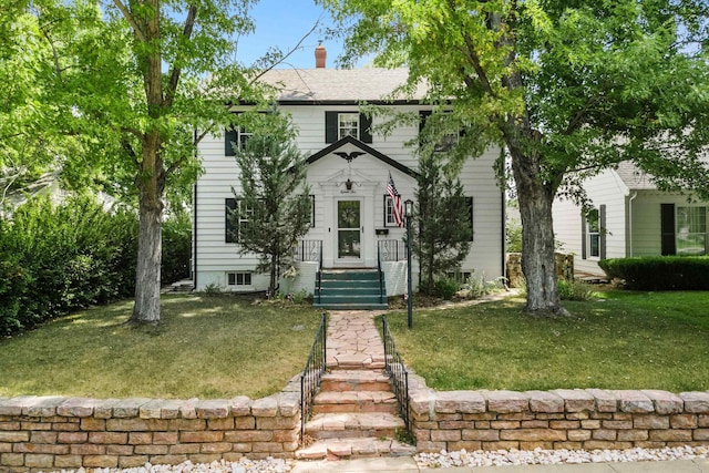 colonial house with a chimney and a front yard